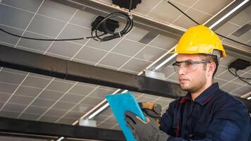 Engineer technical service checking solar panel while monitoring the system of solar panel on his tablet to make sure that's it work properly photo
