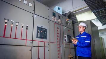 Electrical engineer check the operation of the main electrical control panel photo