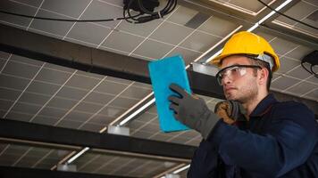 Engineer technical service checking solar panel while monitoring the system of solar panel on his tablet to make sure that's it work properly photo