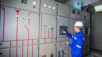 Electrical engineer check the operation of the main electrical control panel photo