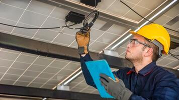 Engineer technical service checking solar panel while monitoring the system of solar panel on his tablet to make sure that's it work properly photo
