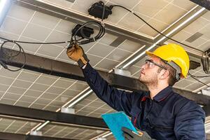 Engineer technical service checking solar panel while monitoring the system of solar panel on his tablet to make sure that's it work properly photo