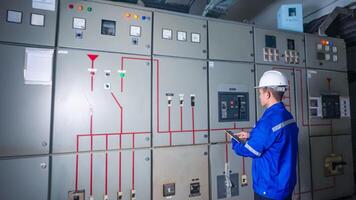 Electrical engineer check the operation of the main electrical control panel photo