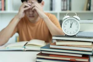 student man have anxiety because of exams, male prepare for test and learning lessons in the library. stress, despair, haste, misunderstanding reading, discouraged, expectation, knowledge, tired photo