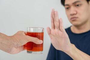 man refuses say no and avoid to drink an alcohol whiskey , stopping hand sign male, alcoholism treatment, alcohol addiction, quit booze, Stop Drinking Alcohol. Refuse Glass liquor, unhealthy, reject photo