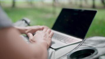 Close-up Programmer is writing code, typing on laptop keyboard. Development, graph analysis and typing on a laptop, work stress, working online, anxiety, working in a park, office syndrome. video
