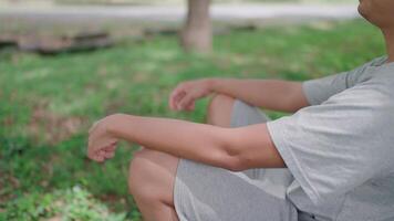 Side view of Asian man leaning on a tree thinking outside sitting on floor, He thinking about life, looking forward with hope while relaxing in a park, Healthy lifestyle. video