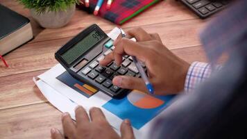 A person is using a calculator on a desk video