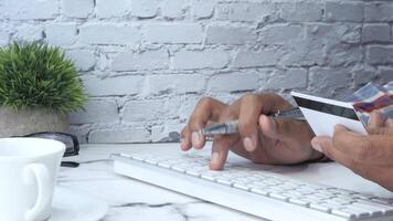 A person using a credit card and a keyboard video