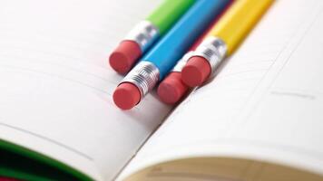 A close up of three colored pencils on an open book video