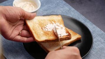 A person is cutting a piece of toast with butter video