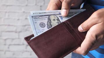 A man holding a wallet with money in it video