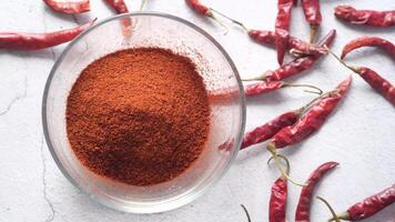 Chili powder in a bowl and red chili peppers video
