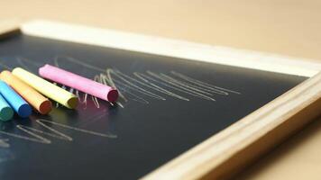 A chalkboard with colored crayons and a pencil video