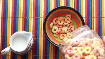 A bowl of cereal and milk on a colorful table video