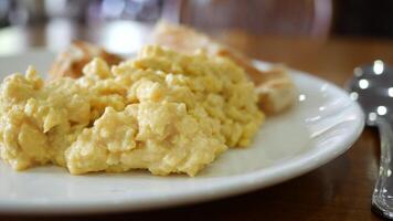 Scrambled eggs on a white plate with a fork video