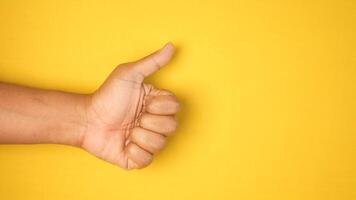 man hand showing a thumb-up against yellow background video