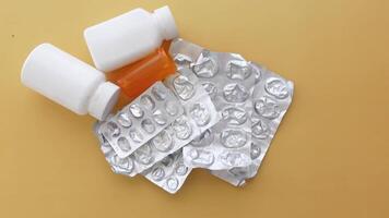 Scattered Medicine Bottles and Empty Blister Packs Displayed on a Bright Yellow Background video