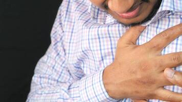 A man is holding his chest and has a heart attack video