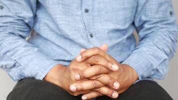 A gentleman with crossed hands, sitting relaxed and thoughtful, exuding calm and elegance video