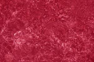 Close-Up of Calm Red Water Surface with Ripples and Reflections photo