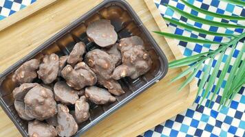 Chocolate covered nuts in a plastic container on a blue and white checkered table video