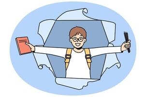 Little schoolboy with books rejoices at beginning of school year, looking out of hole in paper vector