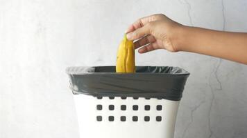 A person is holding a banana in a trash can video