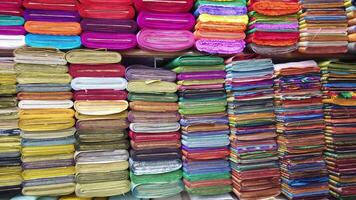 A man standing in front of a large pile of fabric video