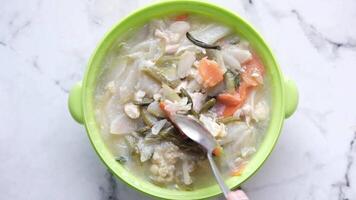 A bowl of soup with vegetables and meat in it video