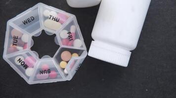 A pill container with pills and a bottle of pills video