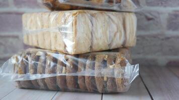A stack of cookies wrapped in plastic sitting on a wooden table video