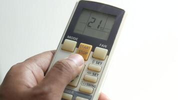 A person holding a remote control with the temperature displayed video