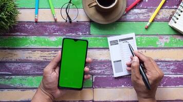 A man is using a smartphone to check his calendar and make a list of tasks video