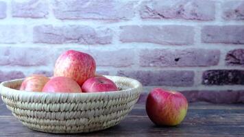 A basket filled with apples on a wooden table video