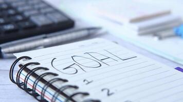 Goal written on a notebook on a desk video