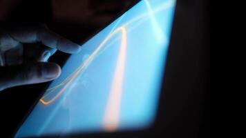 A person is using a tablet computer with a glowing screen video