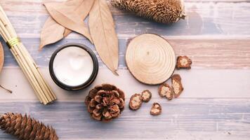 uma tigela do creme, uma bastão do canela e uma pinho cone em uma de madeira mesa video