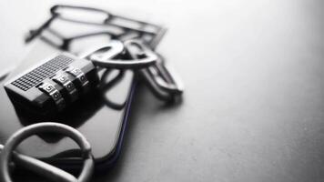 A black and white photo of a cell phone with a padlock video