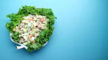 A salad with chicken, vegetables and lettuce on a blue background video