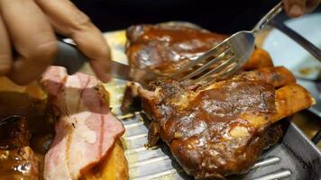 A person cutting meat on a grill with a fork video