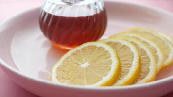 A bowl of lemon slices and a bottle of honey video