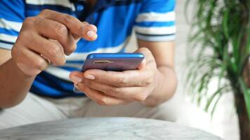 A man is using his cell phone while sitting on a table video