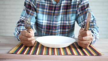 A man is holding two forks and a knife at a table video