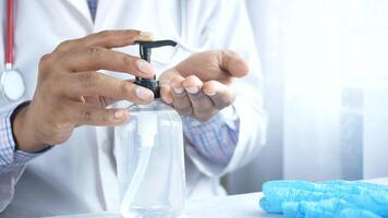 A doctor is using a bottle of hand sanitizer video