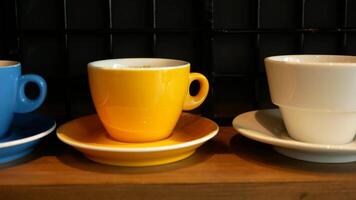 Three different colored cups and saucers sit on a table video