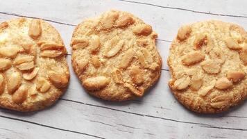 Three cookies with nuts on a wooden surface video