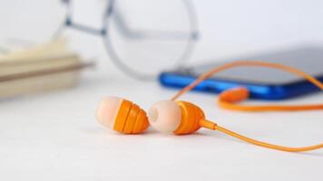 A pair of earphones and a smartphone on a white background video