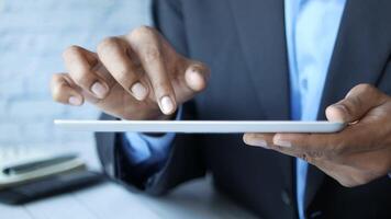 A man in a suit holding a tablet computer video