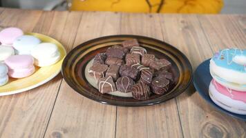 A table with a plate of donuts and a plate of chocolate video